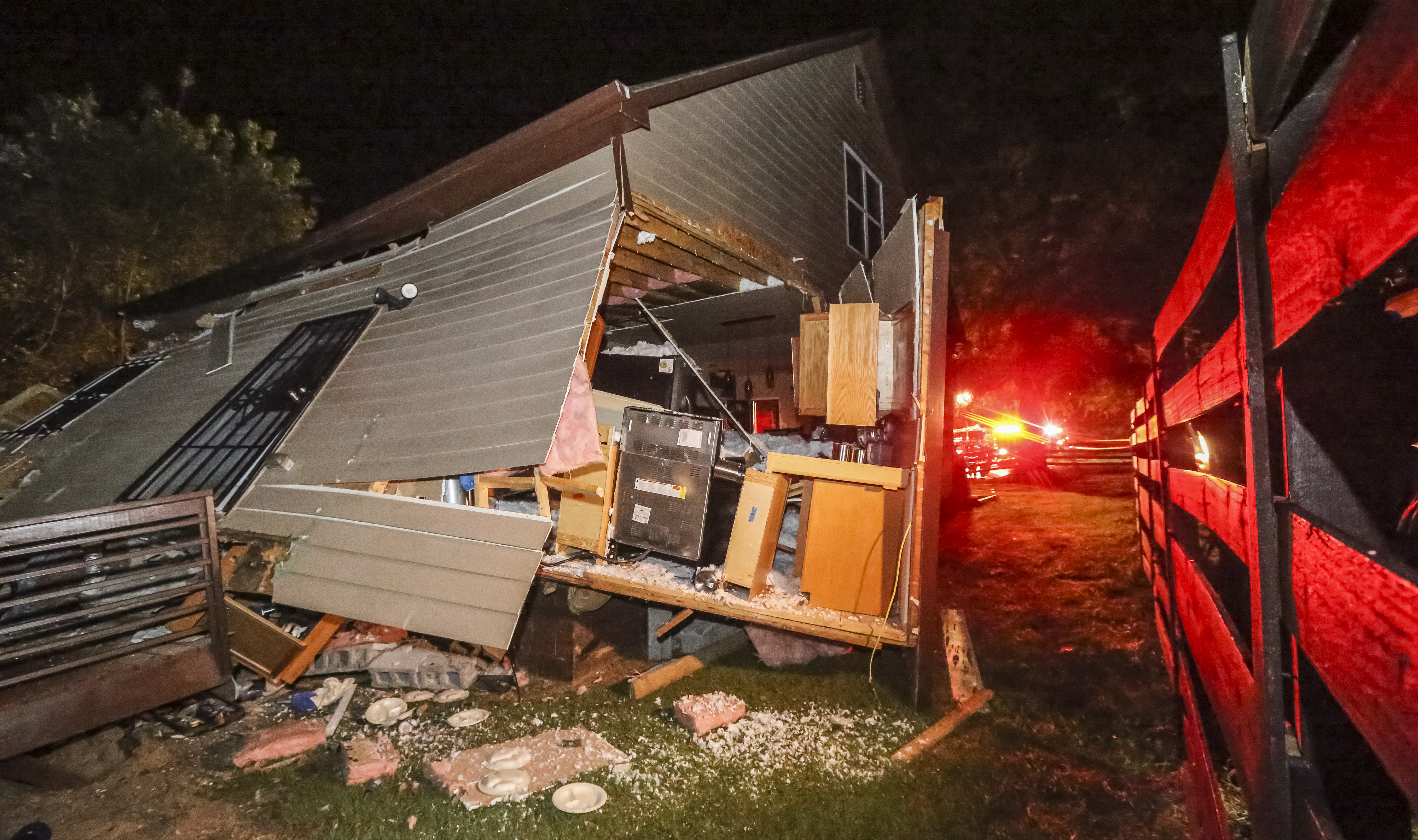 Emergency personnel work at the scene of a train derailment early Thursday, Oct. 5, 2017, in Atlanta. Authorities say the freight train crashed into the bedroom of a home, sending a man inside to a hospital.  (John Spink / Atlanta Journal-Constitution via AP)