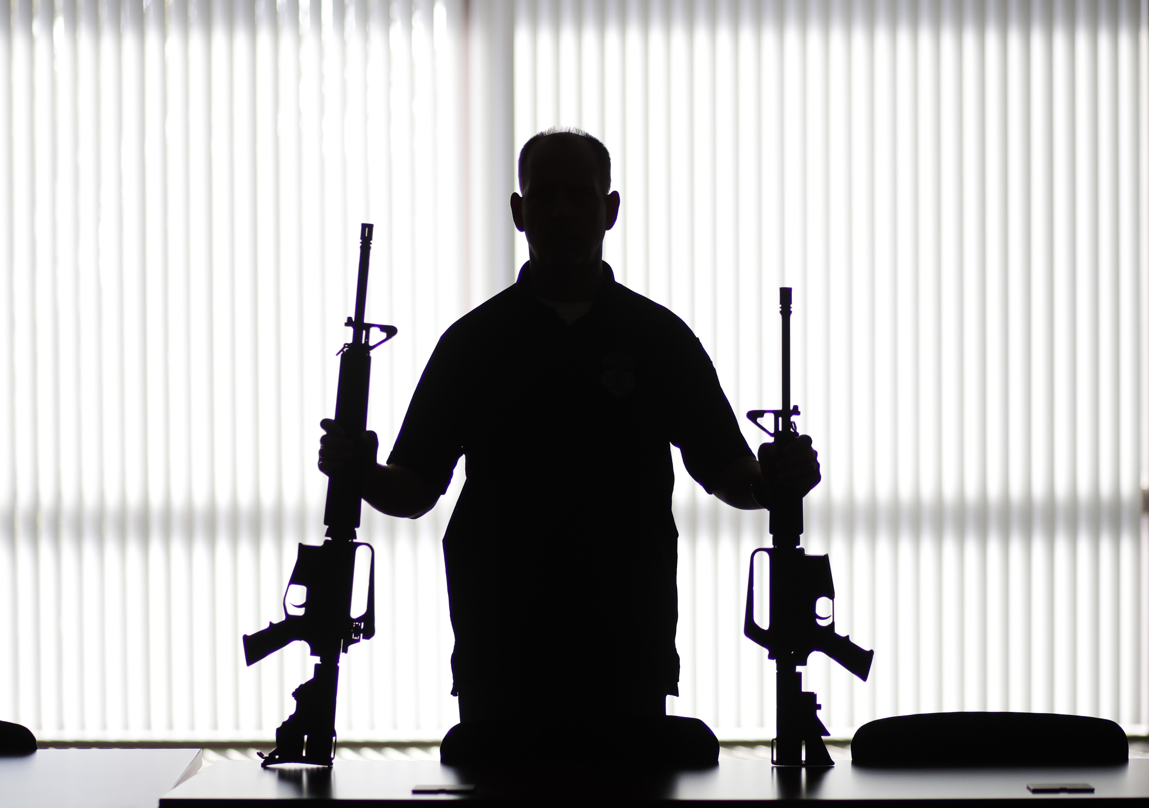 An ATF agent holds two rifles. (Jae C. Hong / AP Photo)