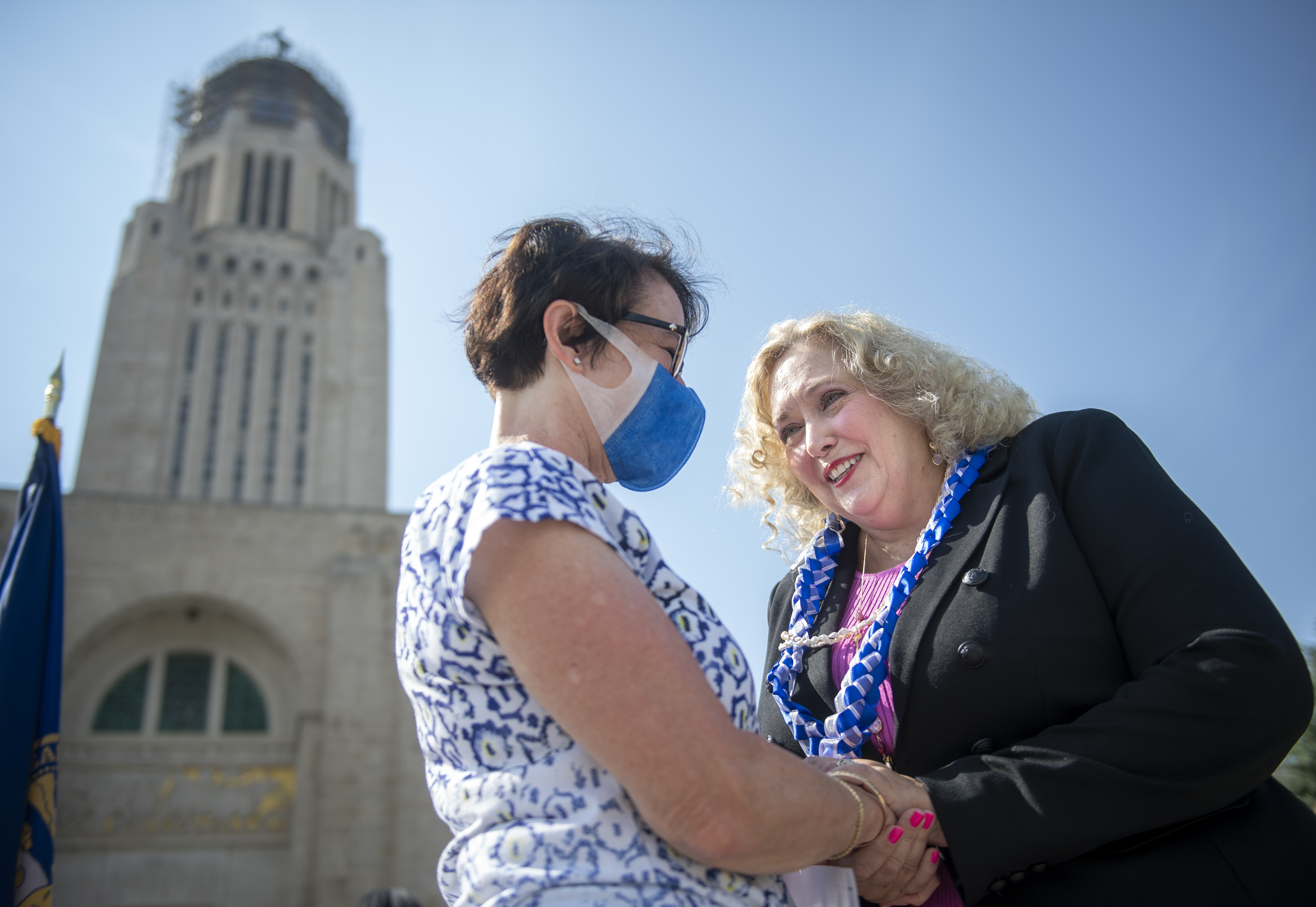 Nebraska state Sen. Carol Blood, right, greets Sharlette Schwenninger of Elmwood, Neb. after Blood announced her candidacy to seek the Democratic gubernatorial nomination outside the Nebraska State Capitol, Monday, Sept. 13, 2021, in Lincoln, Neb. (Justin Wan / Lincoln Journal Star via AP Photo)