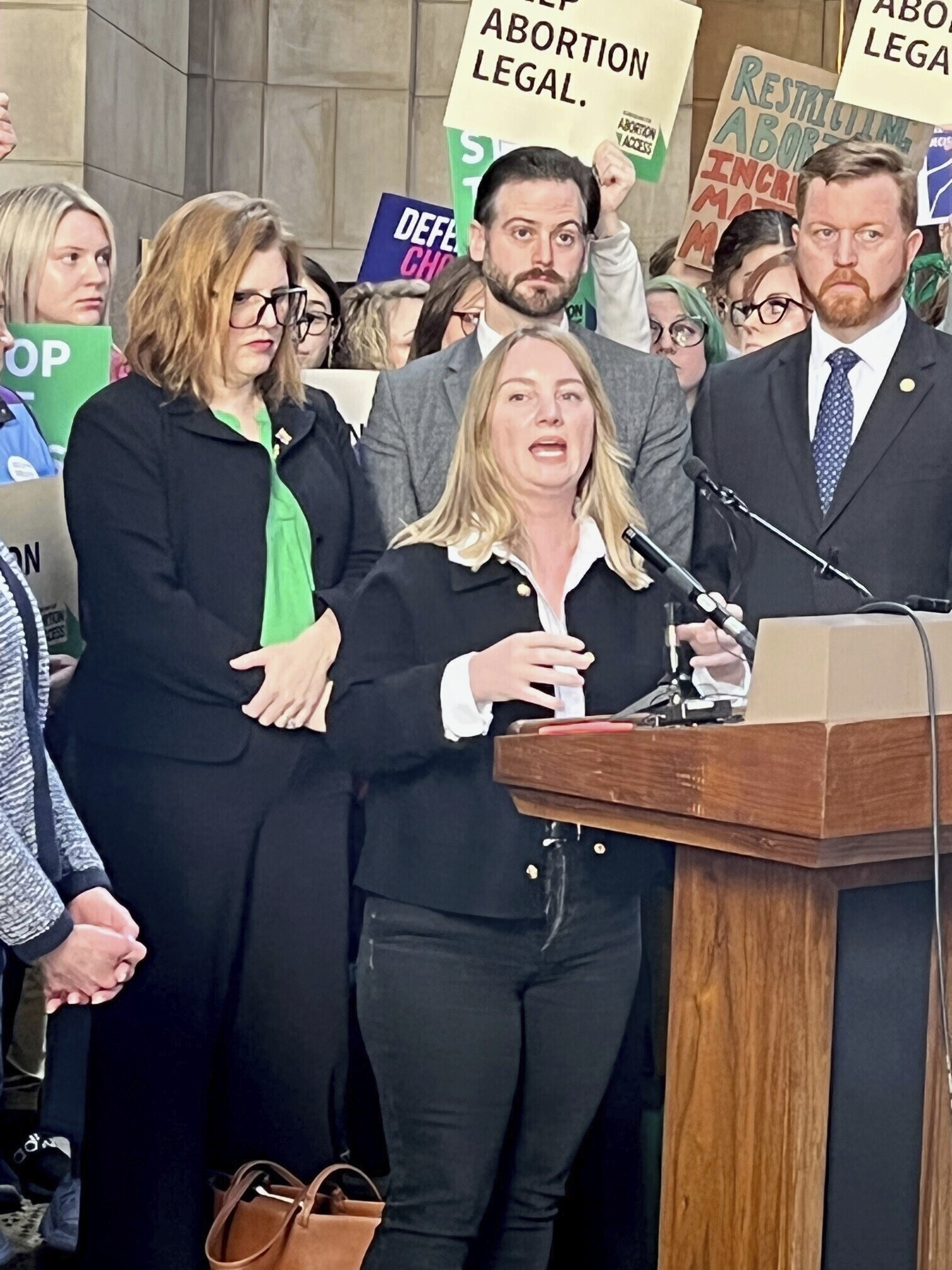 Nebraska state Sen. Megan Hunt, who has been an outspoken opponent of restricting abortion rights, spoke before a crowd of about 300 people, Wednesday, Feb. 1, 2023, in Lincoln, Neb., opposing a so-called heartbeat bill. Behind her, from left to right, are state Sens. Machaela Cavanaugh, George Dungan and John Cavanaugh. (Margery A. Beck / AP Photo)