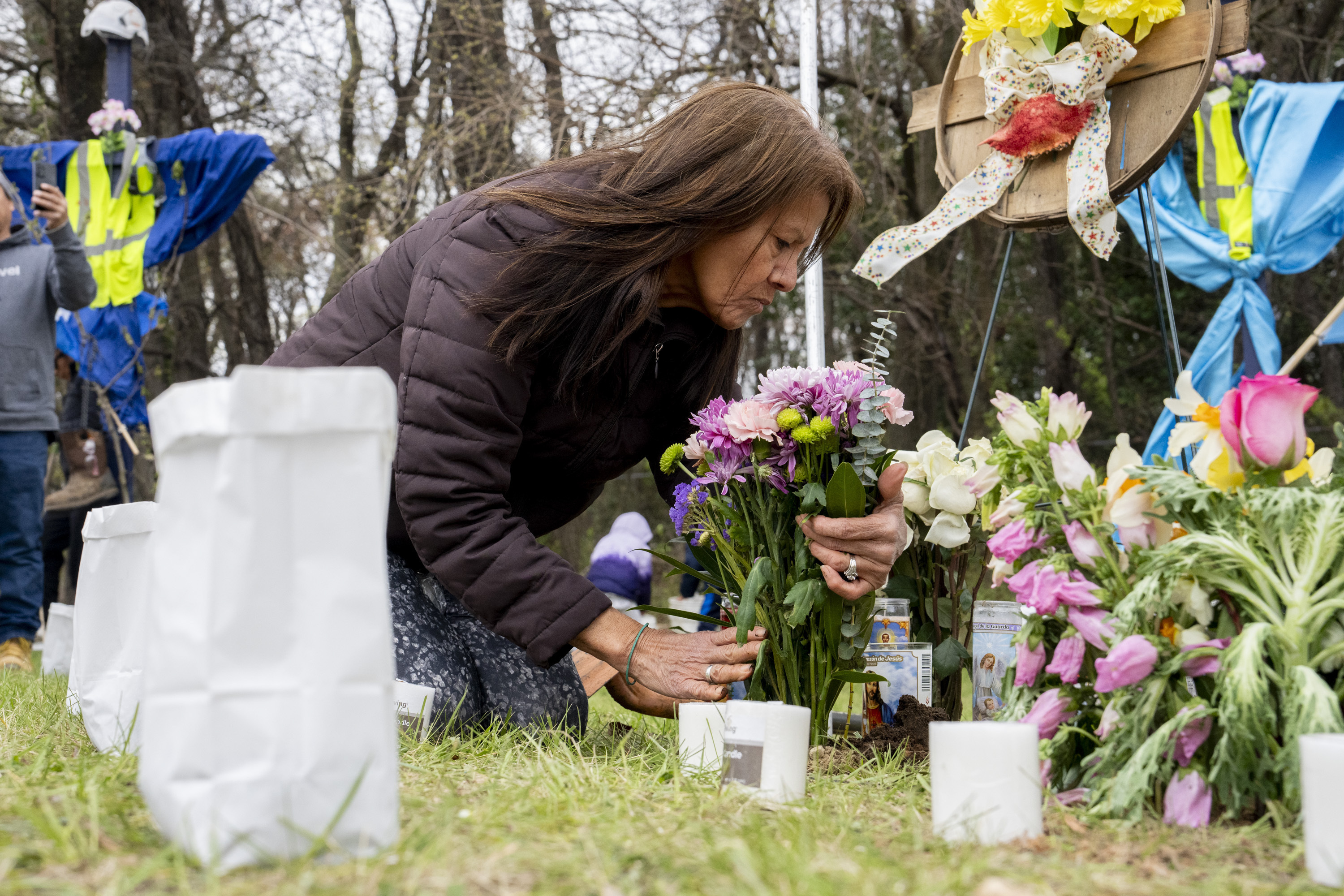 Elisa Salcedo lays flowers, Saturday, April 6, 2024, in front of the memorial site to honor the construction workers who lost their lives in the collapse of the Francis Scott Key Bridge, in Baltimore.<br />(Kaitlin Newman / The Baltimore Banner via AP)