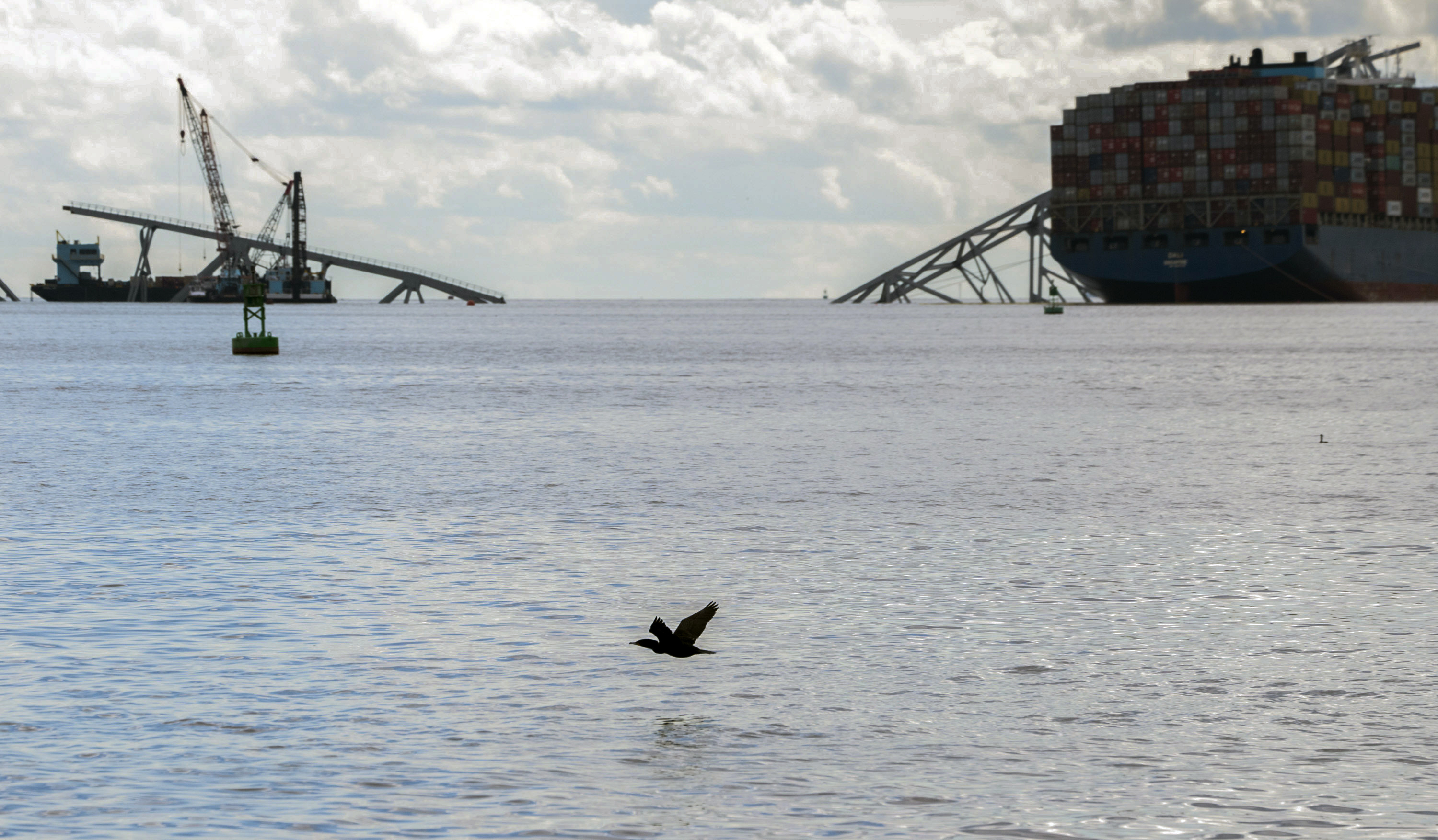 The site of the collapsed Francis Scott Key Bridge and the container ship that toppled it, Dali, right, are seen from a debris retrieval vessel, the Reynolds, April 4, 2024.<br />(Kaitlin Newman / The Baltimore Banner via AP)