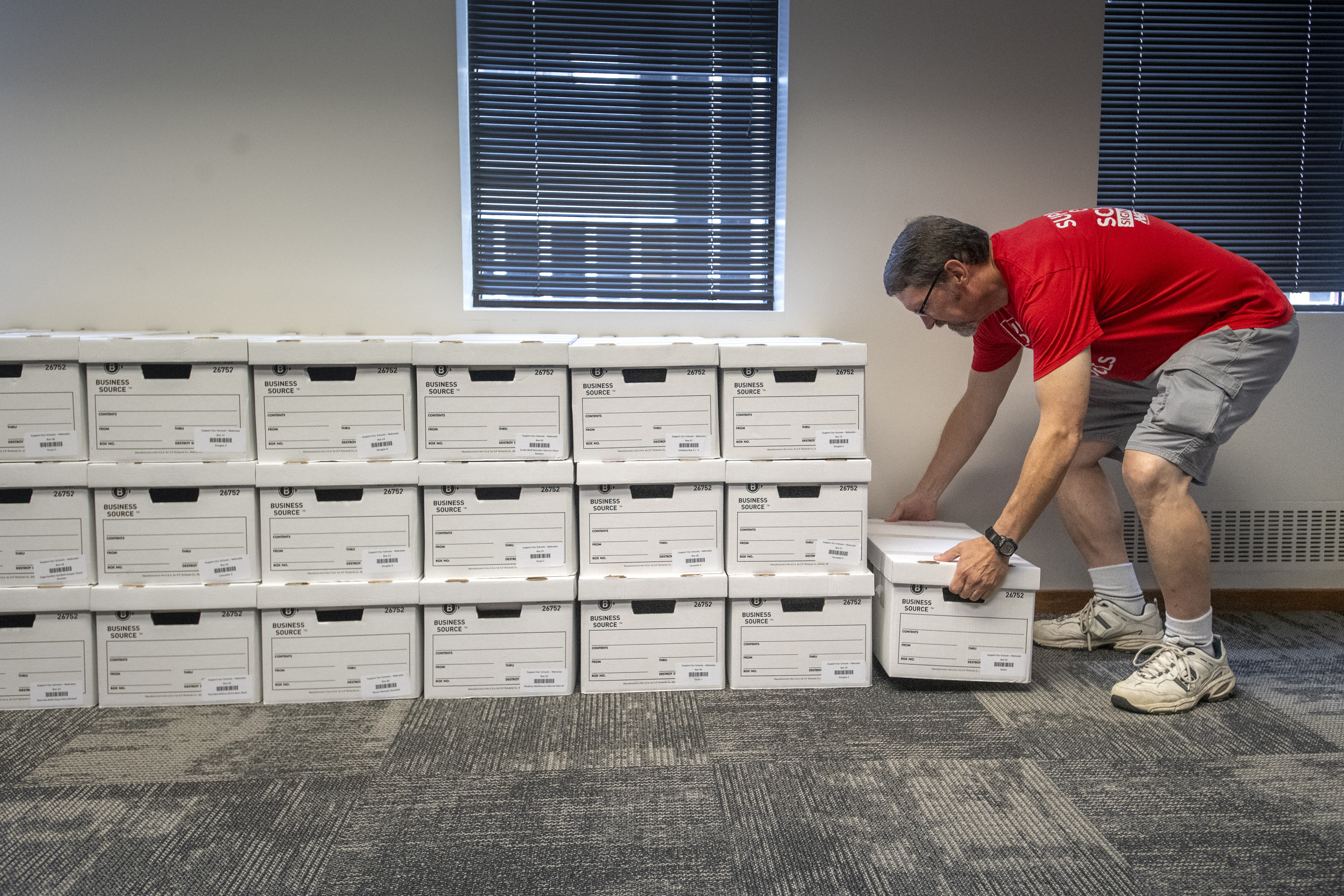 John Heineman delivers a box of petition signatures from Support Our Schools Nebraska to the Nebraska Secretary of State, Aug. 30, 2023, in Lincoln, Neb. Nebraska lawmakers are set for the first time to pass a bill that would block the public from voting on a ballot measure initiated by citizens of the state, setting up what could be a long battle over whether to fund private school tuition with public dollars.<br />(Justin Wan / Lincoln Journal Star via AP)