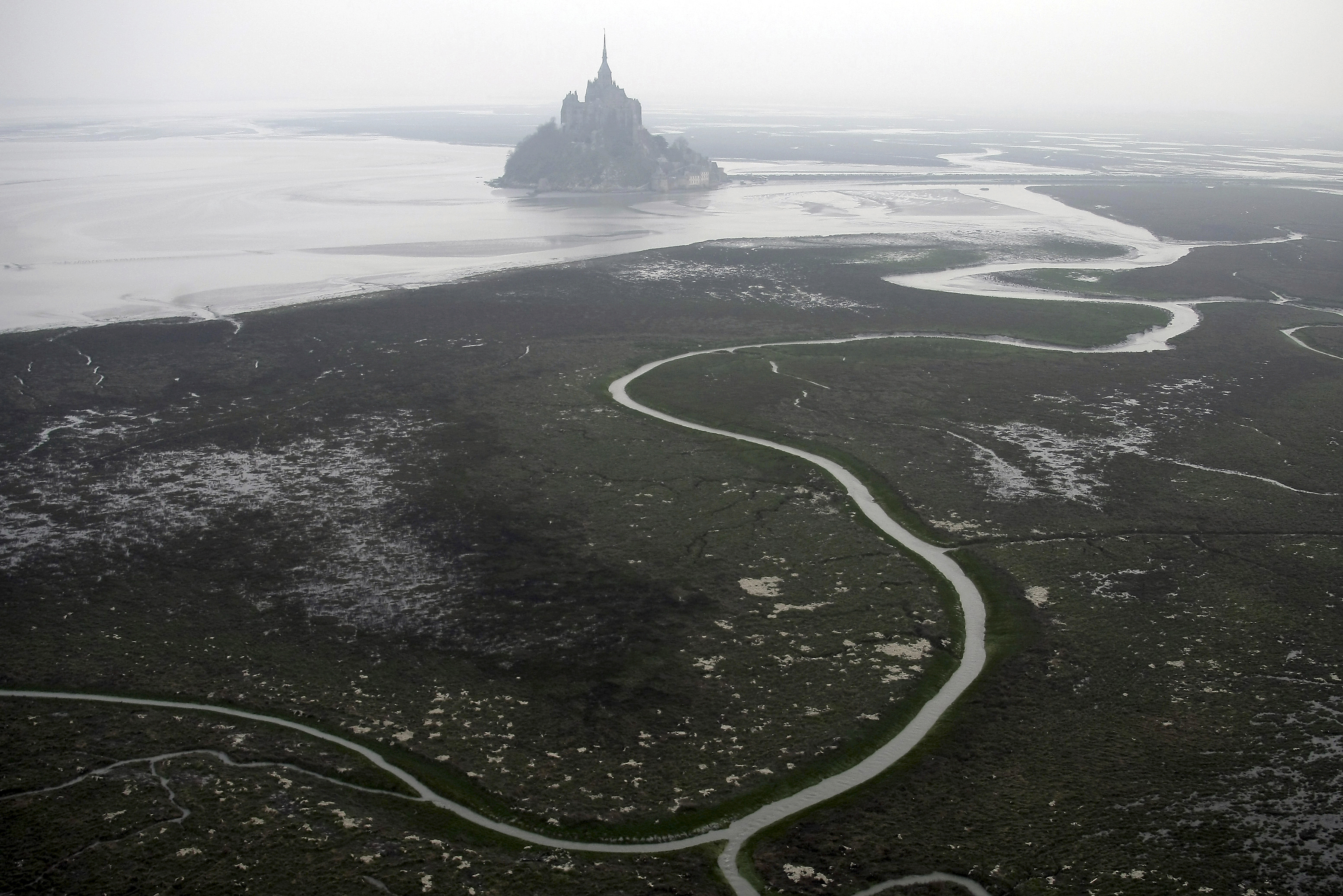 An aerial view of Mont Saint Michel, Normandy, France, March 20, 2011. The Olympic torch finally enters France when it reaches the southern seaport of Marseille on Wednesday May 8, 2024, on an armada from Greece. After leaving Marseille a vast relay route will be undertaken before the torch&#039;s odyssey ends on July 27 in Paris. A notable stop includes the stunning island of Mont-Saint-Michel.<br />(David Vincent / AP Photo)