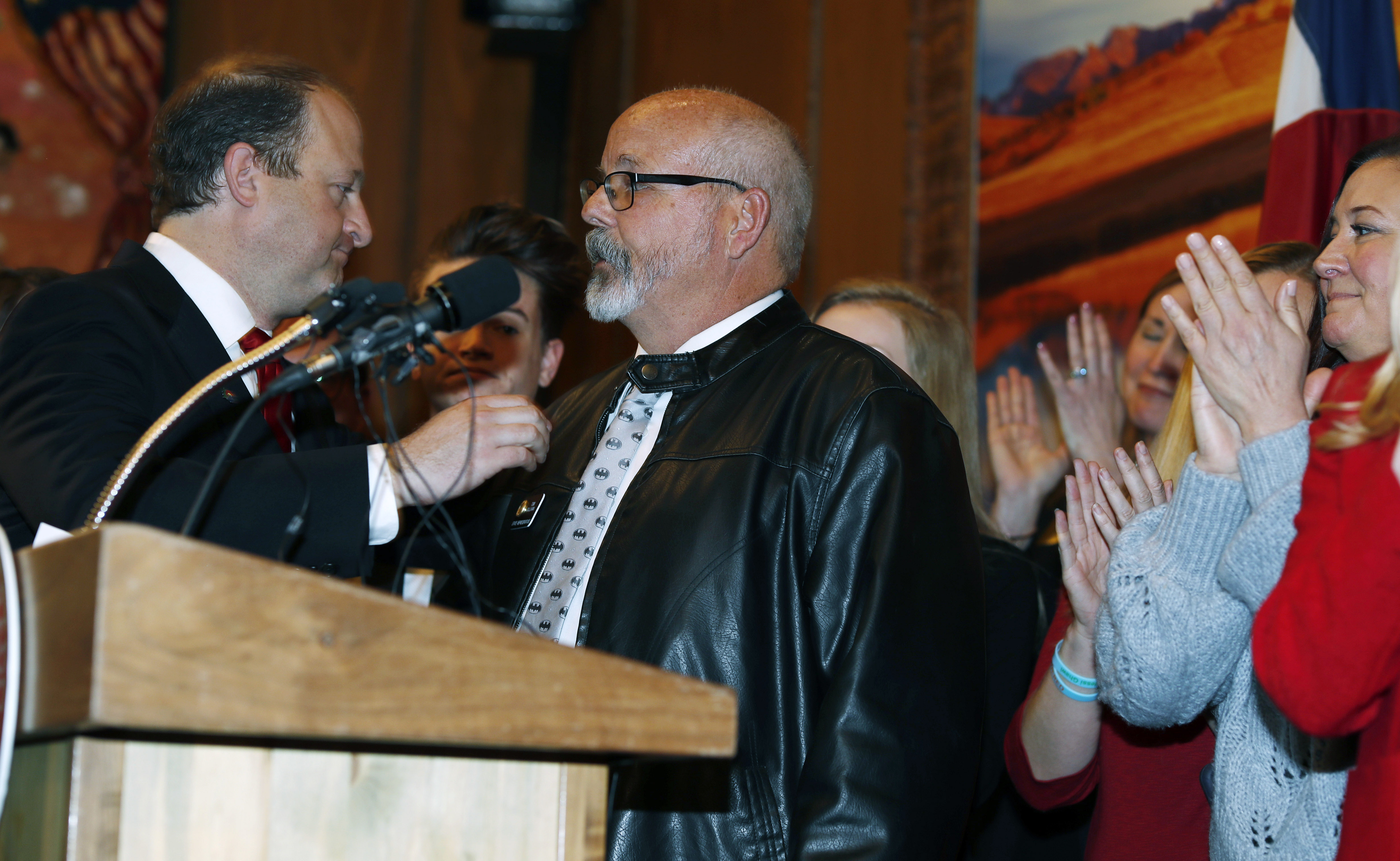 Colorado Gov. Jared Polis, left, reaches out to Rep. Tom Sullivan, D-Aurora, after his statement about the death of his son in a mass shooting at a movie theatre in Aurora during a bill signing ceremony, April 12, 2019, in the State Capitol in Denver.<br />(David Zalubowski / AP Photo)