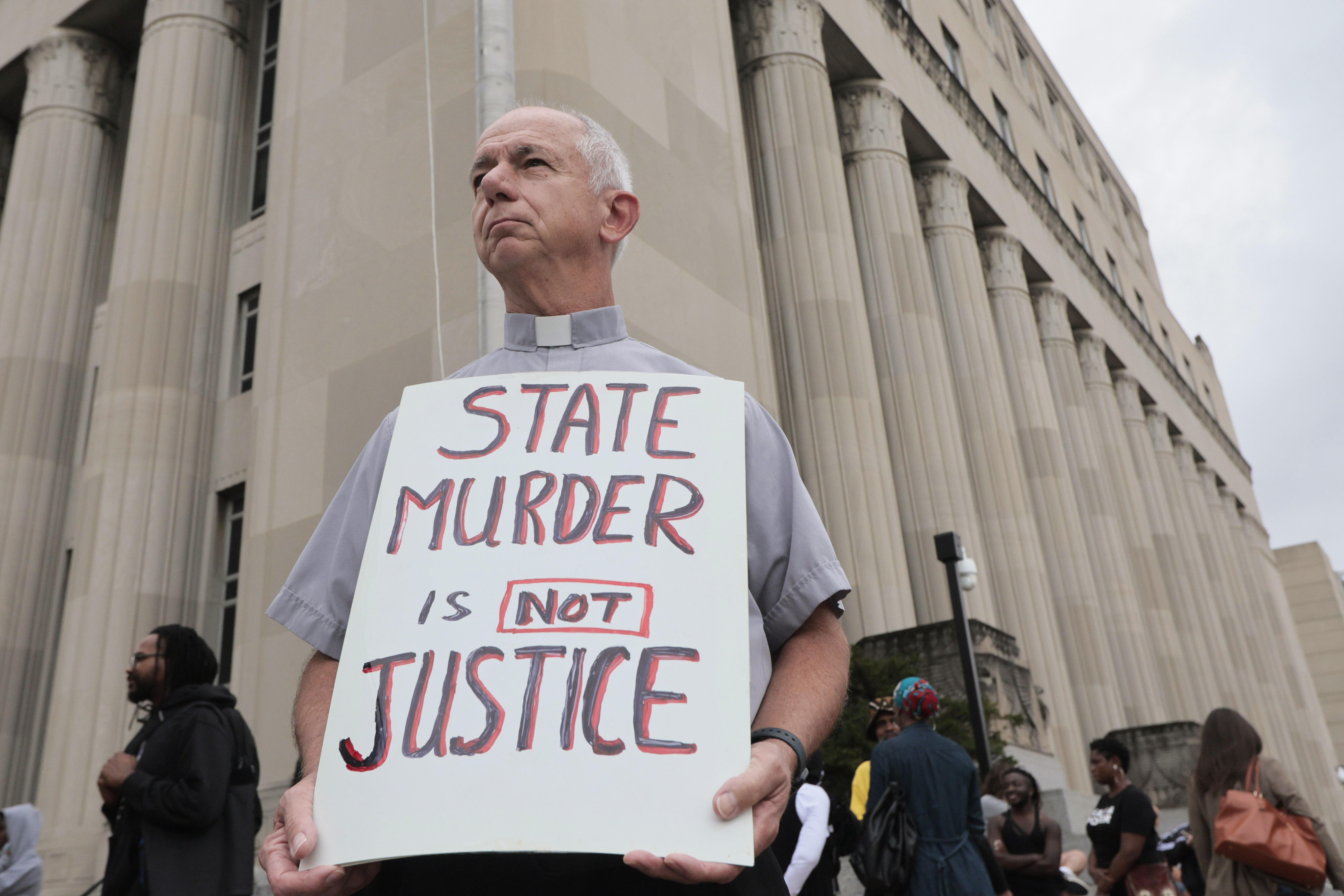 Deacon Dave Billips, with the Office of Peace and Justice with the St. Louis Archdiocese, holds a sign as he stands with protesters holding space to halt the execution of Marcellus Williams on Tuesday, Sept. 24, 2024, outside the Carnahan Courthouse in St. Louis.<br />(Laurie Skrivan / St. Louis Post-Dispatch via AP)