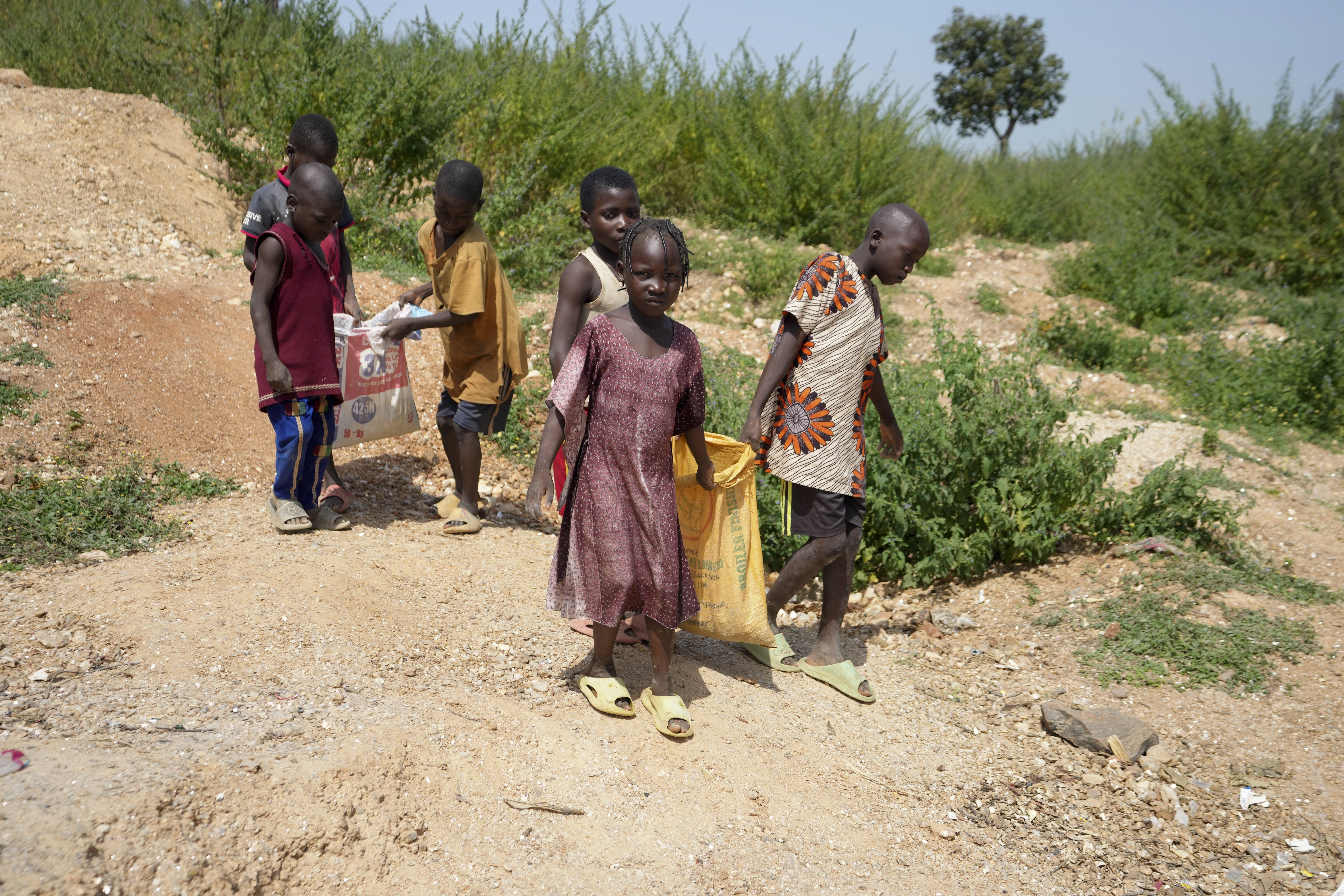 Juliet Samaniya, 6, carries a bag of lithium with other children at an illegal mining site in Paseli, Nigeria, Tuesday, Nov 5, 2024.<br />(Sunday Alamba / AP Photo)