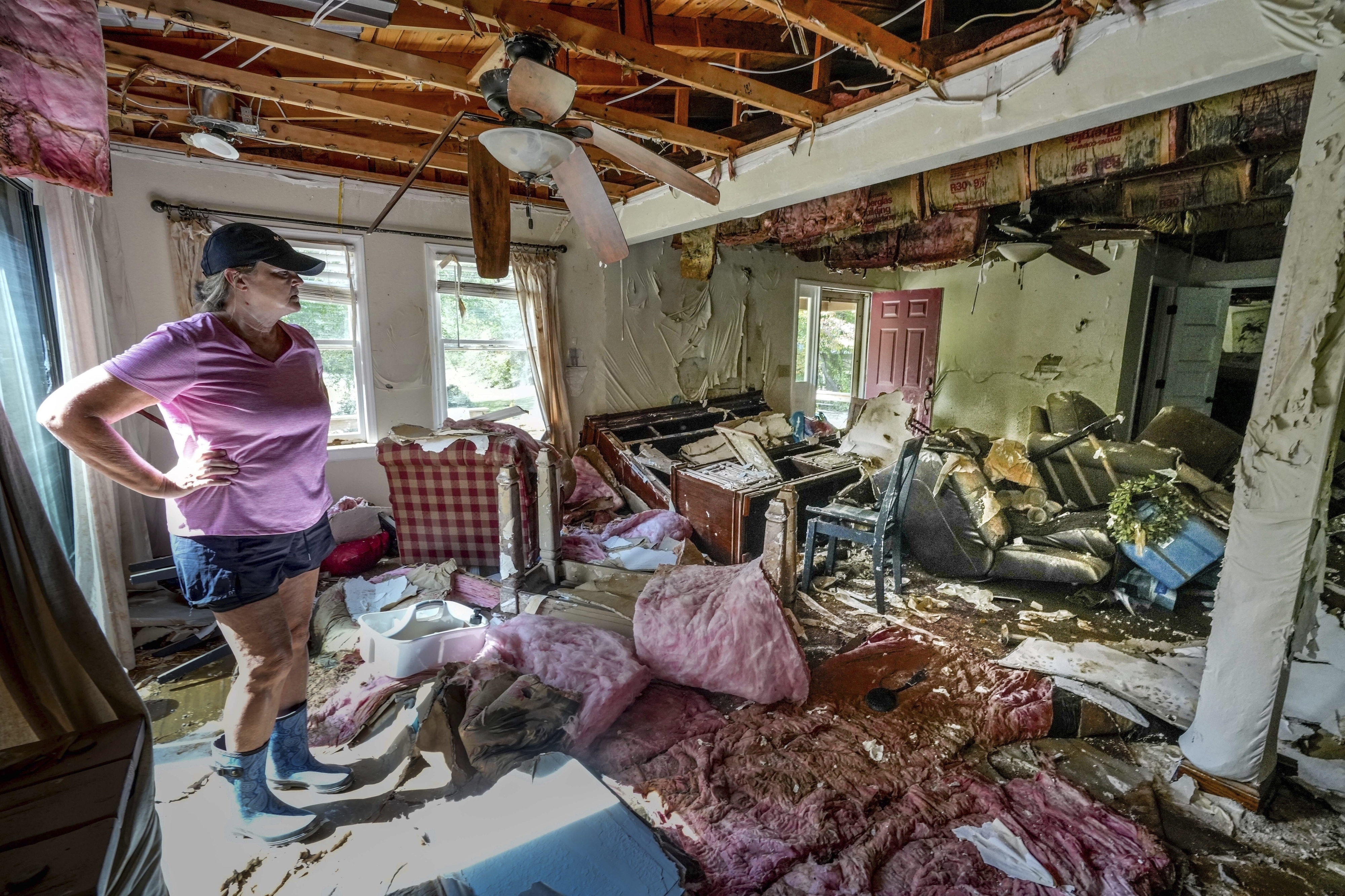 Cindy White looks over the devastation inside her home caused by Hurricane Helene, Tuesday, Oct. 1, 2024 in Morganton, N.C.<br />(Kathy Kmonicek / AP Photo)