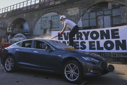 An old Tesla car that was due to be scrapped is hit at an event staged to protest against Elon Musk, organised by the group &#039;Everyone Hates Elon&#039; in London, Thursday, April 10, 2025.<br /> (Kirsty Wigglesworth / AP Photo)
