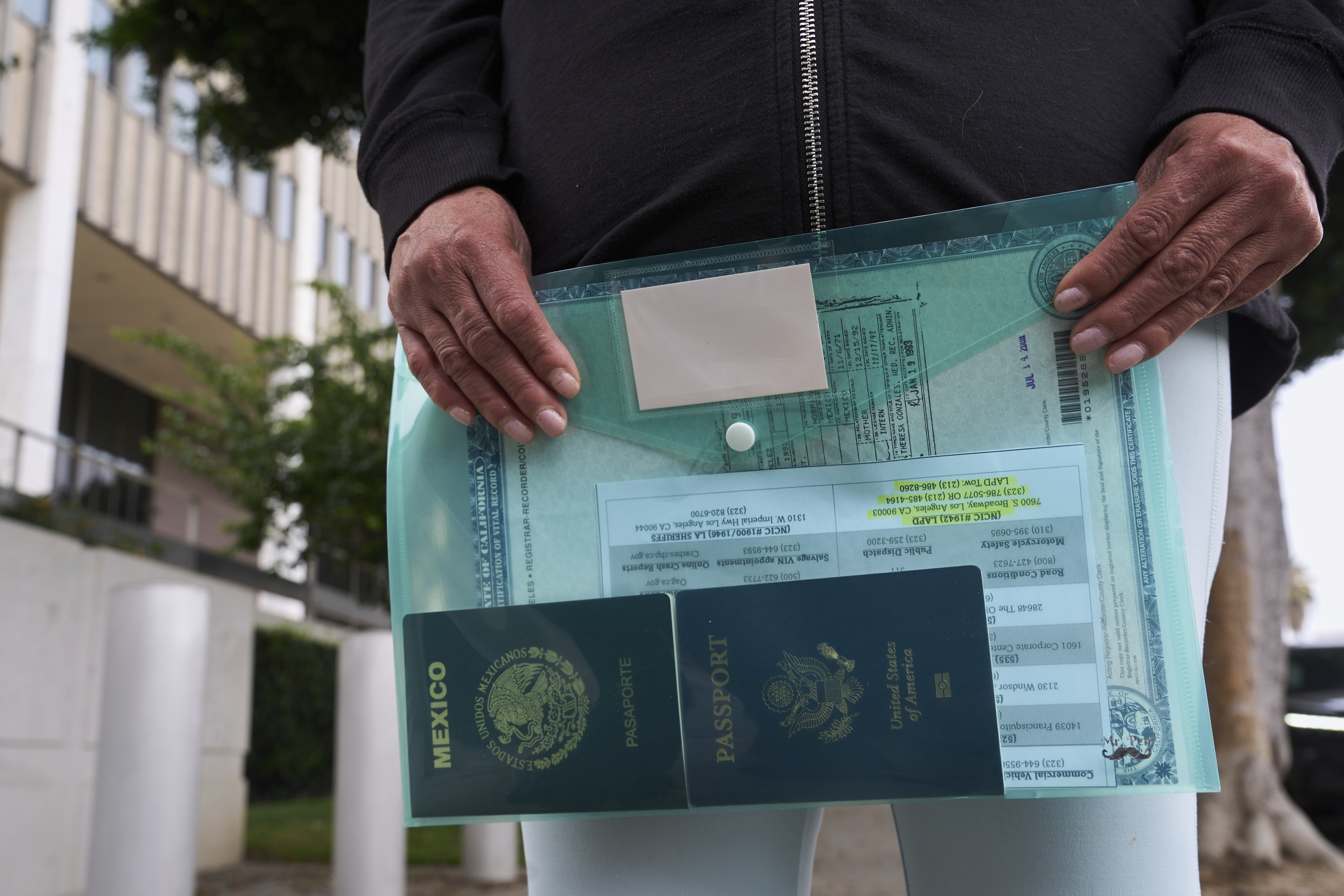 Margarita Flores, mother of Andrea Velez, a U.S. citizen of South L.A, holds to her daughter&#039;s current U.S. passport, and her Mexican passport, as she looks for her location, after ICE agents detained Velez during an immigration raid outside the Metropolitan Detention Center in Los Angeles on Wednesday, June 25, 2025.<br />(Damian Dovarganes / AP Photo)