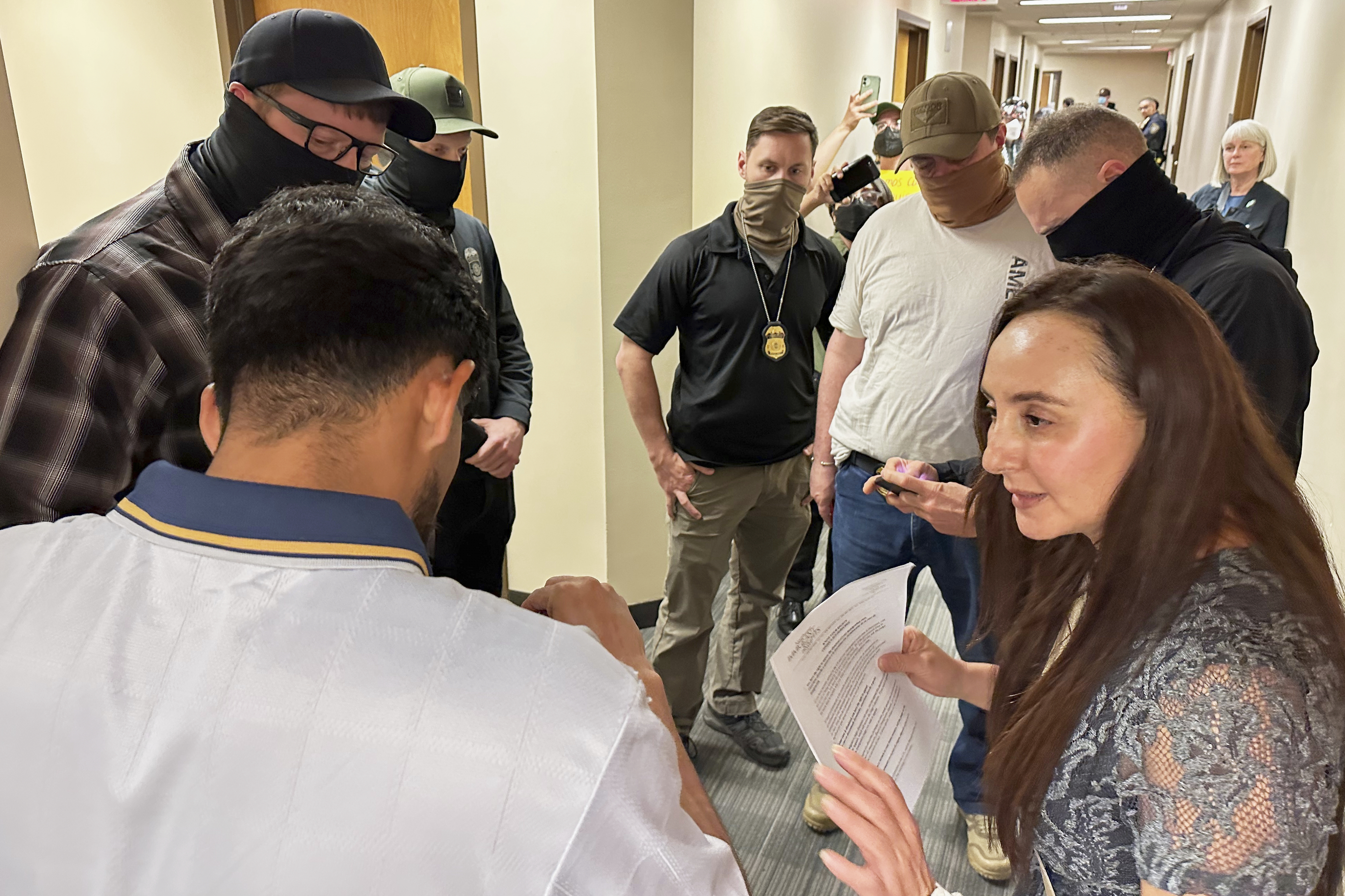 Immigration court volunteer Marjorie Miller gives guidance and support to a Colombian man who was about to be taken into custody by Immigration and Custom Enforcement officers in the hallway after his hearing with an immigration judge in Seattle, June 3, 2025.<br />(Martha Bellisle / AP Photo)