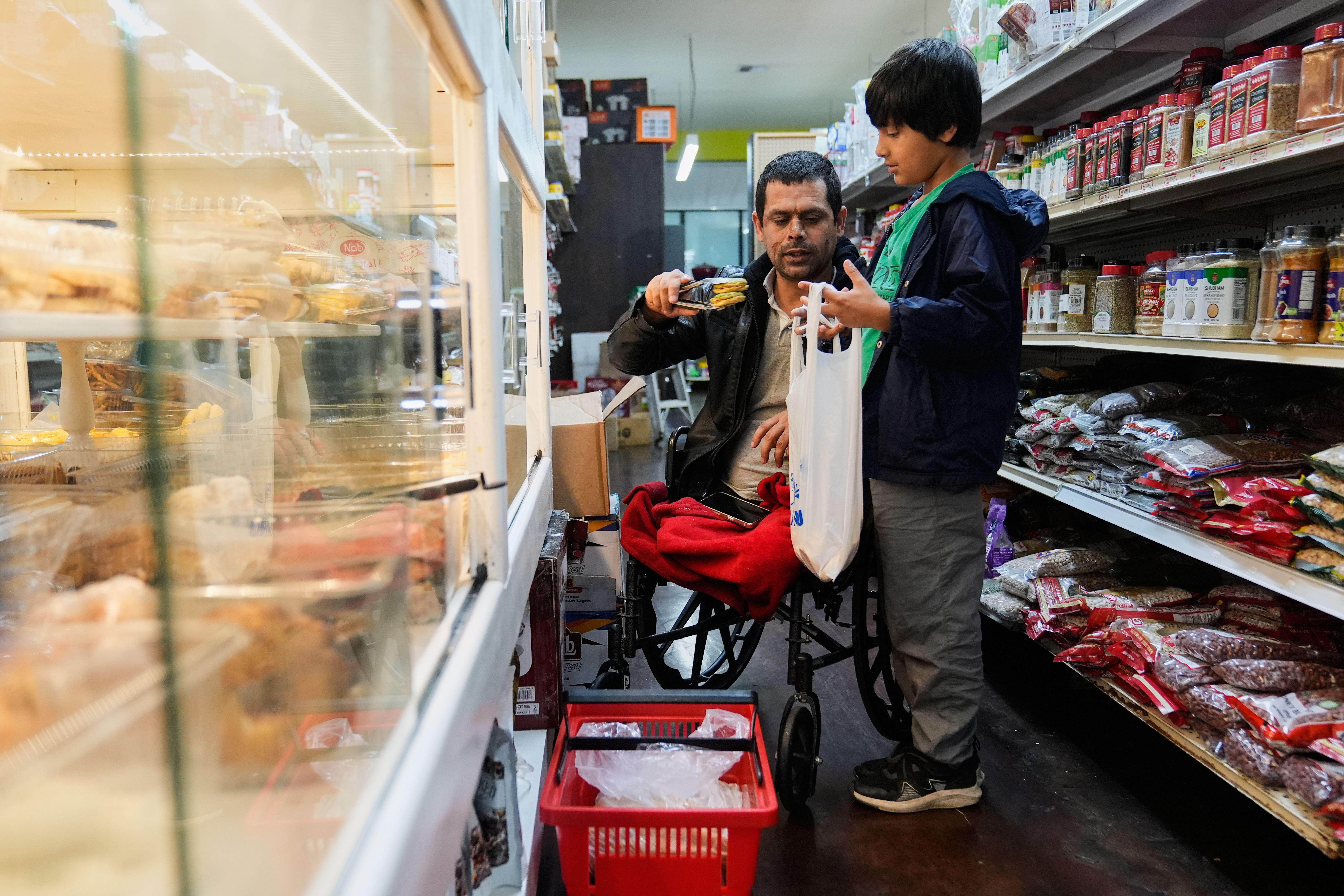 Abdul Salam (center) and his son Ahmad Sodais shop for sweet treats inside of an Afghan grocery store in Carmichael, Calif., Friday, Dec. 5, 2025.<br />(Godofredo A. Vásquez / AP Photo)