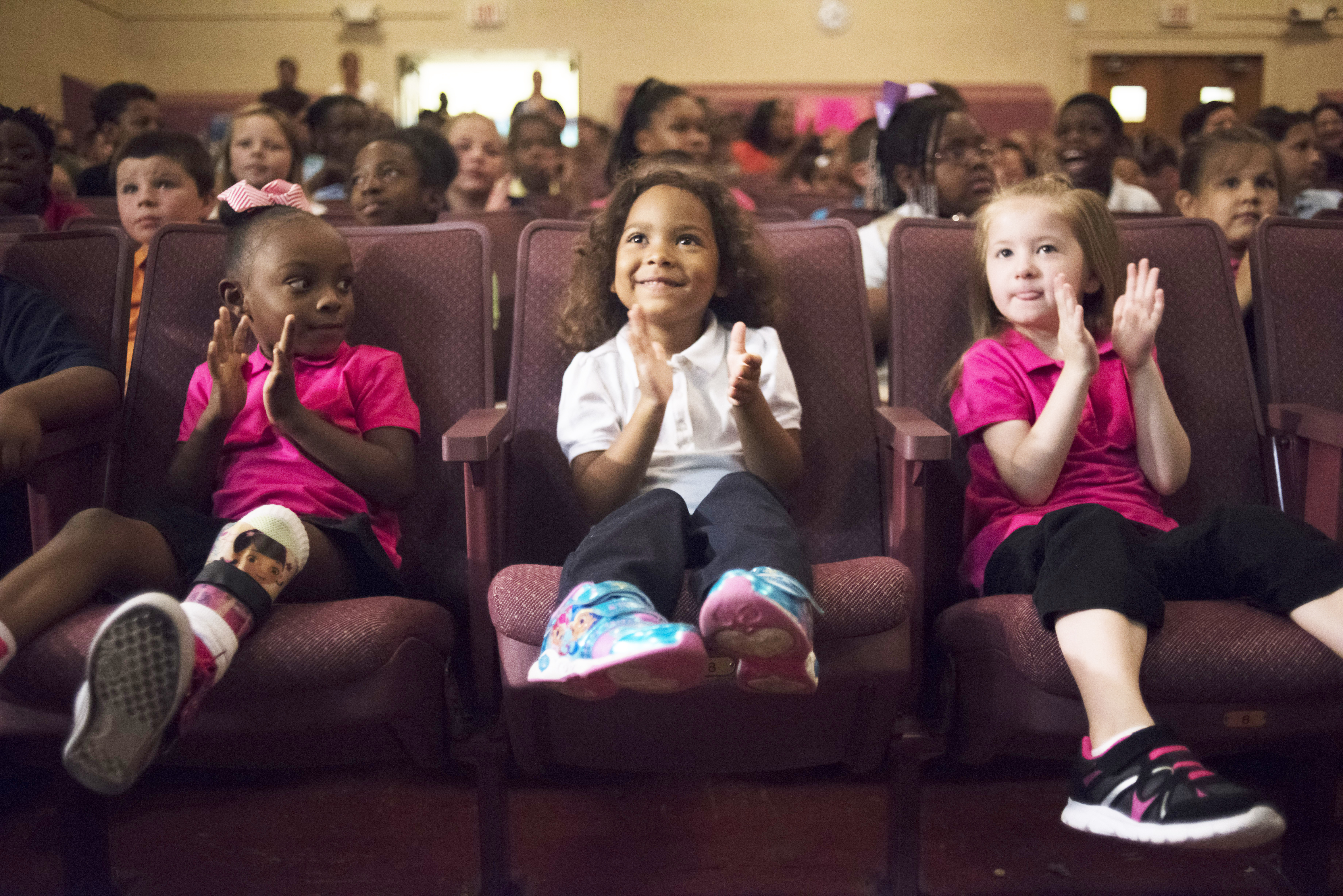 Rosalynn Smith, 5, (center) applauds during the Kids in Need Foundation giveaway at Freeman Elementary, Tuesday, Aug, 30, 2016, in Flint, Mich. The nonprofit group gave backpacks filled with school supplies to all 5,500 students in Flint&#039;s public school district, the latest philanthropic effort aimed at helping the city dealing with the aftermath of a lead-tainted water crisis.<br />(Mark Felix / The Flint Journal-MLive.com via AP)