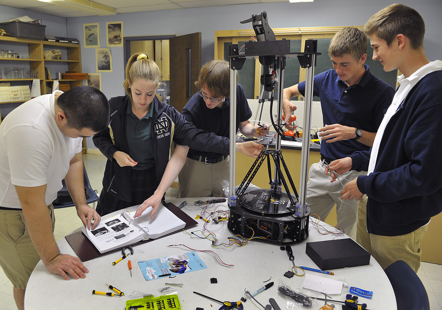 Franni Trivette and Brennan Ward solder the wiring on a 3-D printer they and other students are building from a kit in the pre-engineering class at Notre Dame High School in Wichita Falls, Texas, Monday, Sept. 28, 2015. The project is teaching the students about following instructions, hardware, assembly, troubleshooting and problem solving.<br />(Torin Halsey / Wichita Falls Times Record News via AP)