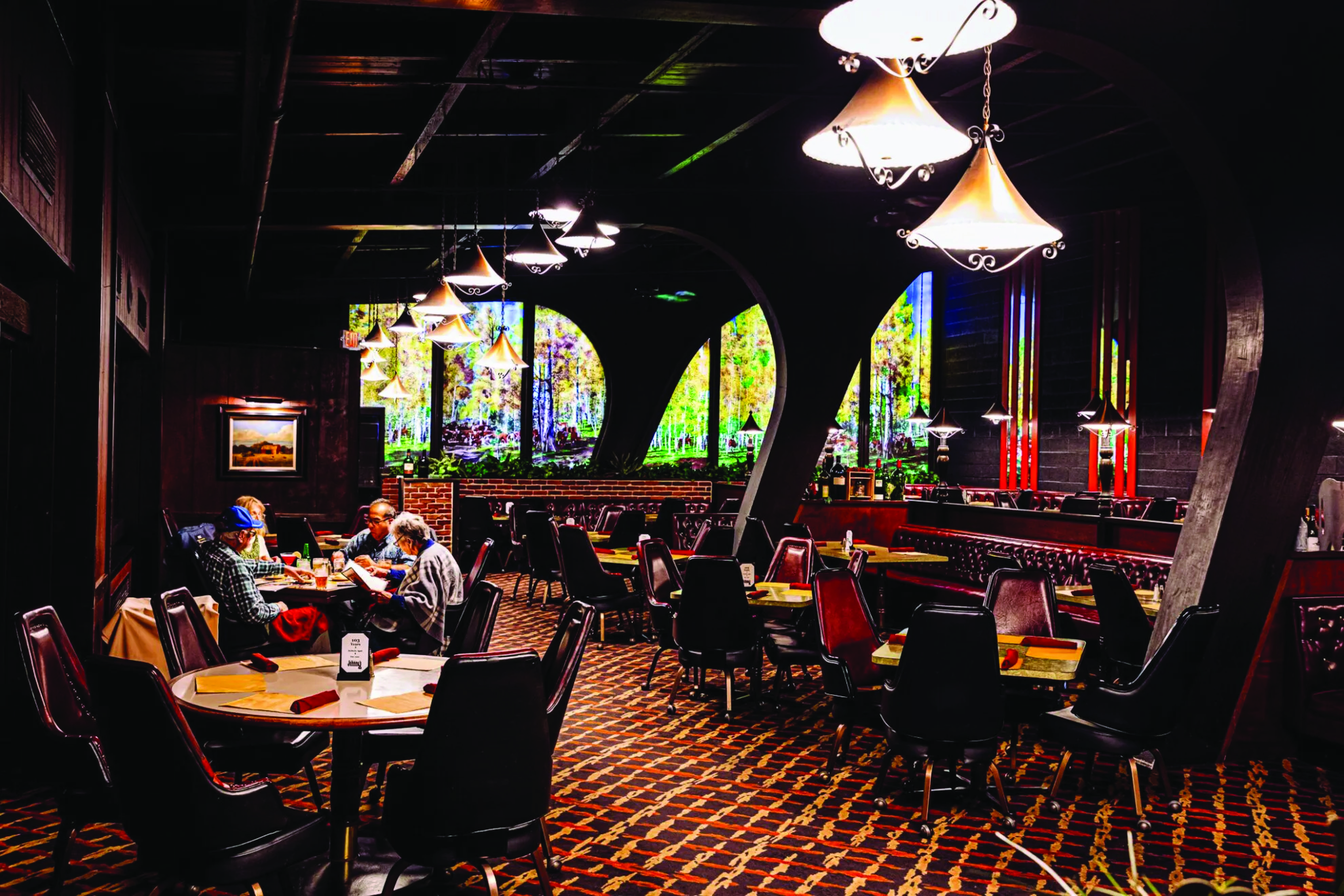 The dining room at Johnny’s Cafe in Omaha. The interior of the restaurant dates from a remodel in the early 1970s, including the now-iconic backlit landscape mural on the dining room’s south wall.<br />(Joshua Foo / Flatwater Free Press)