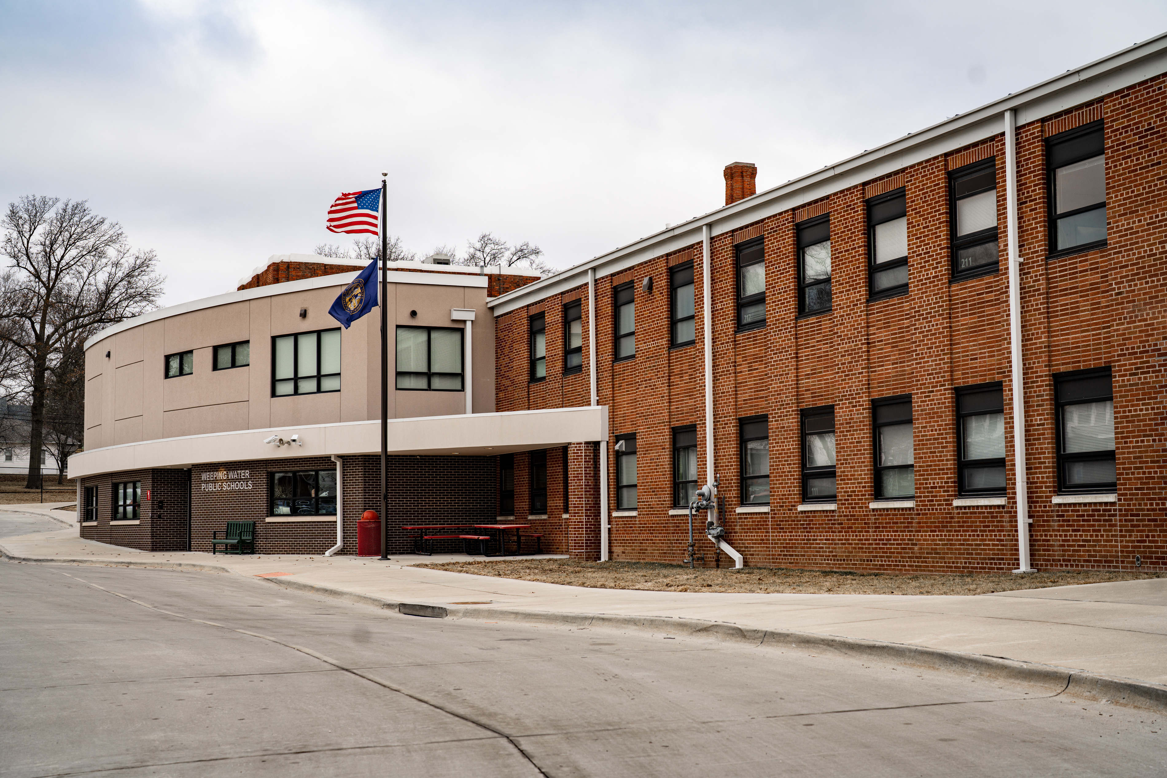 An exterior photo of Weeping Water Public Schools during a recent school day. The school’s 299 students attend classes in this building. This year, they switched to a four-day week after the school struggled to attract and retain teachers. “Smaller schools, we don’t have the financial resources to throw money at people to stay,” said Superintendent Kevin Reiman. “I just can’t compete with those types of things.” (Abiola Kosoko / Flatwater Free Press)