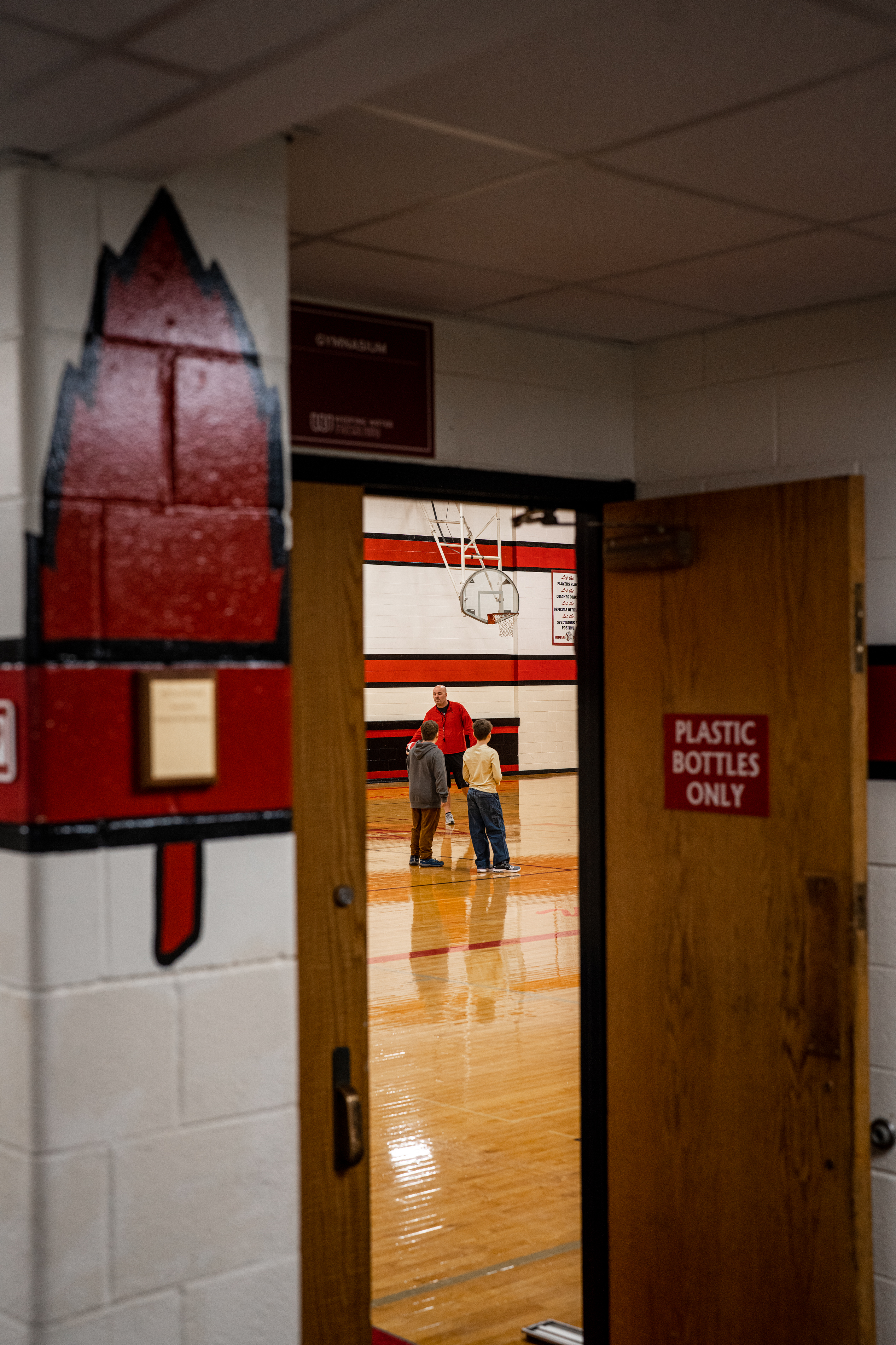 Adam McGill coaches during elementary physical education in Weeping Water’s old basketball gym. Teachers report far reduced stress since the switch to a four-day school week, and parents have generally supported the move, too. For younger students, especially kindergartners, the slightly longer school day has sometimes proven difficult.<br />(Abiola Kosoko / Flatwater Free Press)