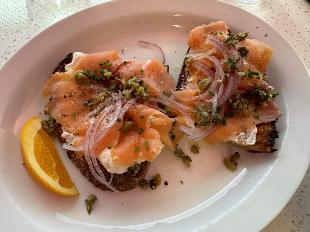 A New York style classic served on crusty bread made at Omaha’s Le Quartier bakery, the Lox toast includes salmon, whipped cream cheese, capers, shaved onion and dill.<br />(Sarah Baker Hansen / Flatwater Free Press)