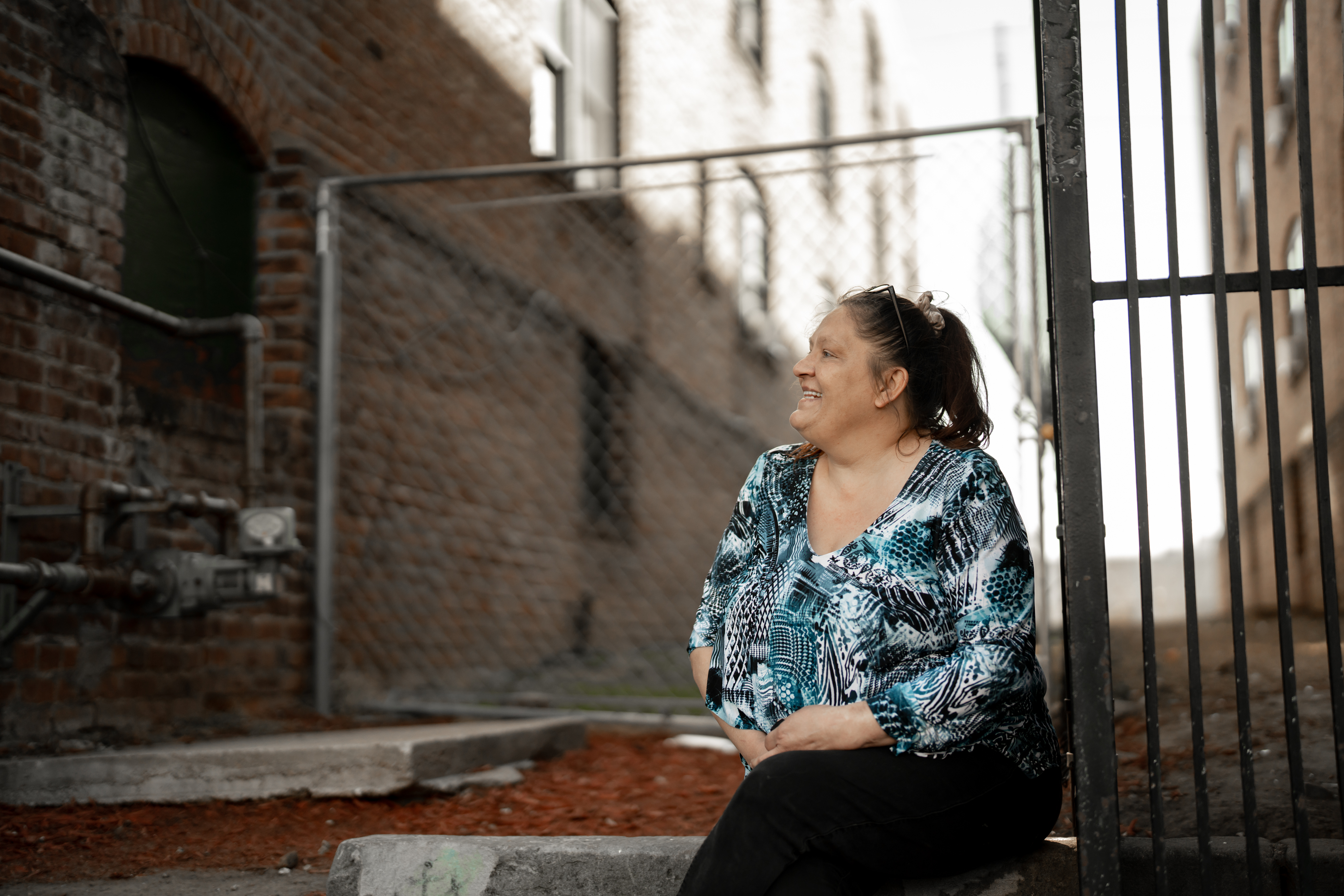Mendy Race sits outside her new apartment building in Omaha about a month after OHA evicted her from public housing.<br />(Abiola Kosoko / Flatwater Free Press)