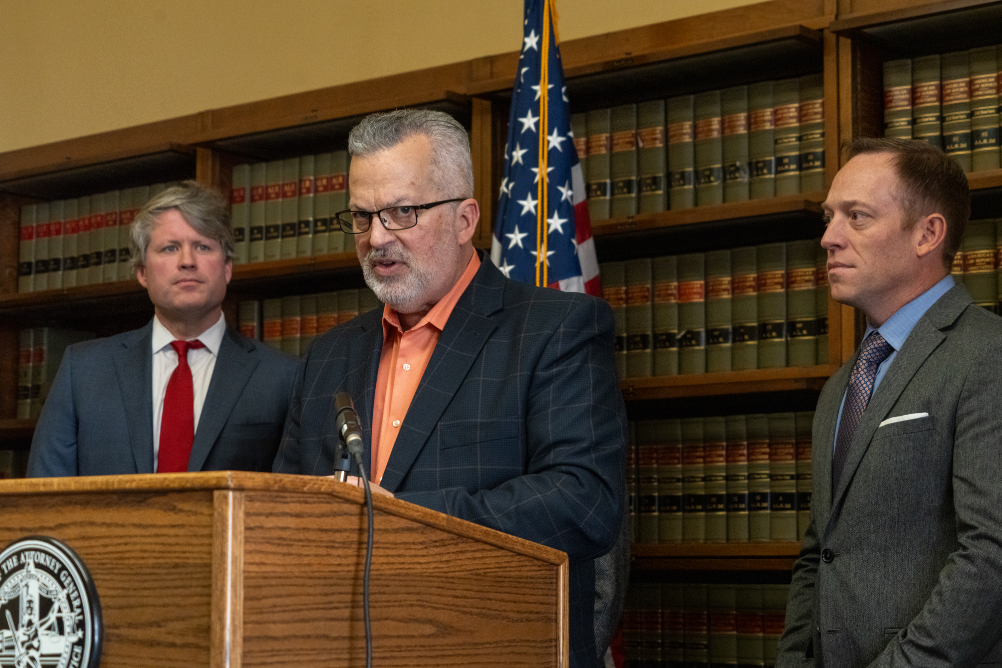 Kent Grisham, president and CEO of the Nebraska Trucking Association, joins Nebraska Attorney General Mike Hilgers in announcing a new lawsuit against four semitruck manufacturers and a trade association on Nov. 19, 2024.<br /> (Zach Wendling / Nebraska Examiner)