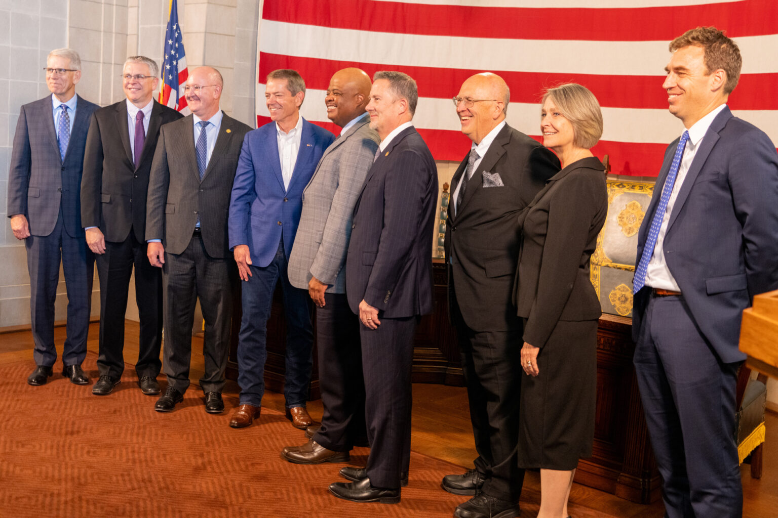 The justices of the Nebraska Supreme Court join Nebraska Gov. Jim Pillen (center left in a blue suit) and Lt. Gov. Joe Kelly (far left) for the elevation of Douglas County District Judge Derek Vaughn (center) to the Supreme Court. Vaughn’s colleagues, from left: are Justice John Freudenberg, Jason Bergevin, Jeffrey Funke (chief), William Cassel, Stephanie Stacy and Jonathan Papik, Nov. 10, 2025.<br />(Zach Wendling / Nebraska Examiner)