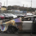 A member of the Seattle Fire Department inspects a burned Tesla Cybertruck at a Tesla lot in Seattle, Monday, March 10, 2025. 
(Lindsey Wasson / AP Photo)