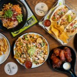 Dishes from the Omaha location of 30Hop include, from top left: an Ahi poke bowl, shrimp tacos, Buffalo wings, nachos and chicken strips.
 (Courtesy photo)