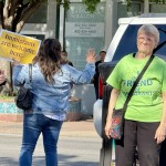 Rallygoers wave at ing cars that honk and give thumbs up to the “Stand in Solidarity” event Thursday afternoon in South Omaha.
(Cindy Gonzalez / Nebraska Examiner)