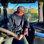 Quentin Connealy looks back at his crops from the seat of his tractor. Connealy, who has been farming full time for the past 15 years, said he has had to deal with increasingly extreme weather. 
(Photo courtesy of Quentin Connealy via Flatwater Free Press) 
