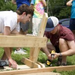 Jack Cicin (left) and Jared Haynes build a wooden bench during a Strong Towns gathering in North Omaha on June 1. The group later placed the benches at bus stops that lacked seating. 
(Jeremy Turley / Flatwater Free Press)