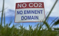 A sign reading “No CO2, no eminent domain” stands along a rural road east of Bismarck, N.D., on Aug. 15, 2023. Summit Carbon Solutions plans to build a 2,000-mile network of CO2 pipelines across the Midwest to capture carbon produced by ethanol plants and then sequester it underground in North Dakota. The Stanton County denial would require Summit Carbon Solutions to reapply for conditional use permit.
(Jack Dura / AP Photo)