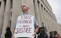 Deacon Dave Billips, with the Office of Peace and Justice with the St. Louis Archdiocese, holds a sign as he stands with protesters holding space to halt the execution of Marcellus Williams on Tuesday, Sept. 24, 2024, outside the Carnahan Courthouse in St. Louis. 
(Laurie Skrivan / St. Louis Post-Dispatch via AP)
