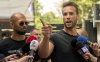 Andrew Tate (left) watches his brother Tristan speak, outside a police station in Voluntari, Romania, Wednesday, May 21, 2025.
 (Vadim Ghirda / AP Photo)