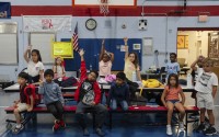 Children raise their hands while participating in activities during the East Providence Boys and Girls Club Summer Camp at Emma G. Whiteknact Elementary School on Thursday, July 10, 2025, in Providence R.I. 
(Sophie Park / AP Photo)