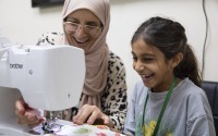 Amal Alalim helps a student in a sewing class at Olive Community Services, Tuesday, July 29, 2025, in Fullerton, Calif. The class was part of the organization's Intergenerational Summer Camp. 
(Zoë Meyers / AP Photo)