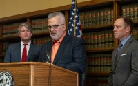 Kent Grisham, president and CEO of the Nebraska Trucking Association, joins Nebraska Attorney General Mike Hilgers in announcing a new lawsuit against four semitruck manufacturers and a trade association on Nov. 19, 2024.
 (Zach Wendling / Nebraska Examiner)