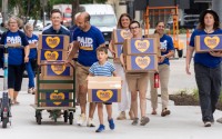 Advocates for a minimum degree of paid sick leave for Nebraska workers brought boxes of petition signatures to downtown Lincoln before bringing them to the Nebraska Secretary of State’s Office on June 27, 2024. 
(Zach Wendling / Nebraska Examiner)