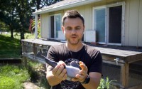Peter Tudor, a member of the Omaha Racing Pigeon Association, handles a pigeon in front of a loft on his Omaha property. 
(Jeremy Turley / Flatwater Free Press )
