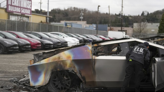 A member of the Seattle Fire Department inspects a burned Tesla Cybertruck at a Tesla lot in Seattle, Monday, March 10, 2025. 
(Lindsey Wasson / AP Photo)