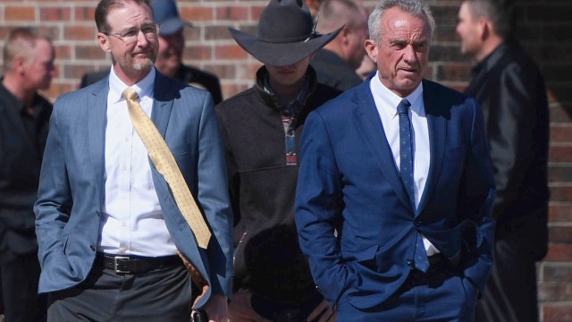 Health and Human Services Secretary Robert F. Kennedy Jr. (right) stands with Dr. Ben Edwards (left) outside the Reinlander Mennonite Church in Seminole, Texas, on Sunday, April 6, 2025, after a second measles death. 
(Annie Rice / AP Photo)