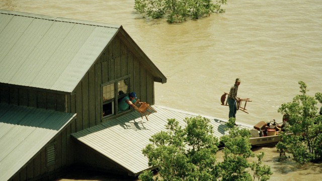 A family moves belongings out of a second floor window of a farm house to a waiting boat near Bristol, T.X., in Ellis County on Saturday, May 5, 1990.
(Pat Sullivan / AP Photo)