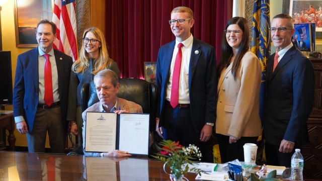 Nebraska Gov. Jim Pillen, seated (at center) holds up a newly signed executive order barring state health officials from diverting federal survivor benefits for youths in foster care to cover the costs of their care, Jan. 27, 2026.
(Courtesy of Nebraska Department of Health and Human Services)