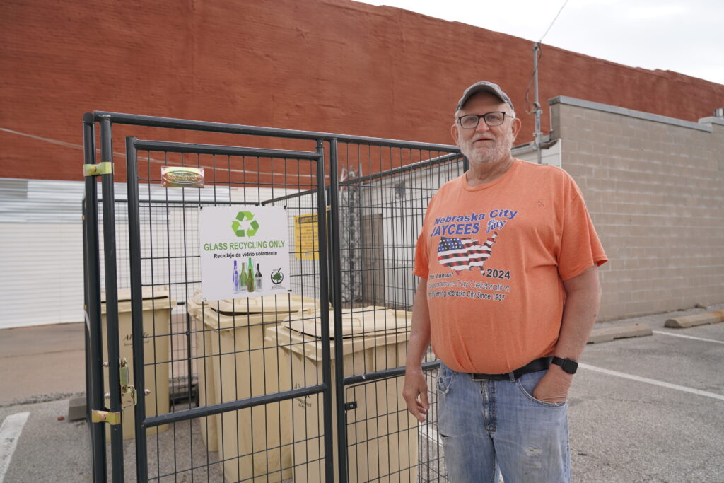 Daryl Steinman, standing in front of Nebraska City’s newly launched glass recycling site. When he was little, glass was recycled at a time when it was profitable. Nowadays, glass recycling is only available in about two dozen Nebraska cities and towns due to high transportation costs to ship recycled glass to the nearest processing facilities near Denver or Kansas City.<br />(Yanqi Xu / Flatwater Free Press)