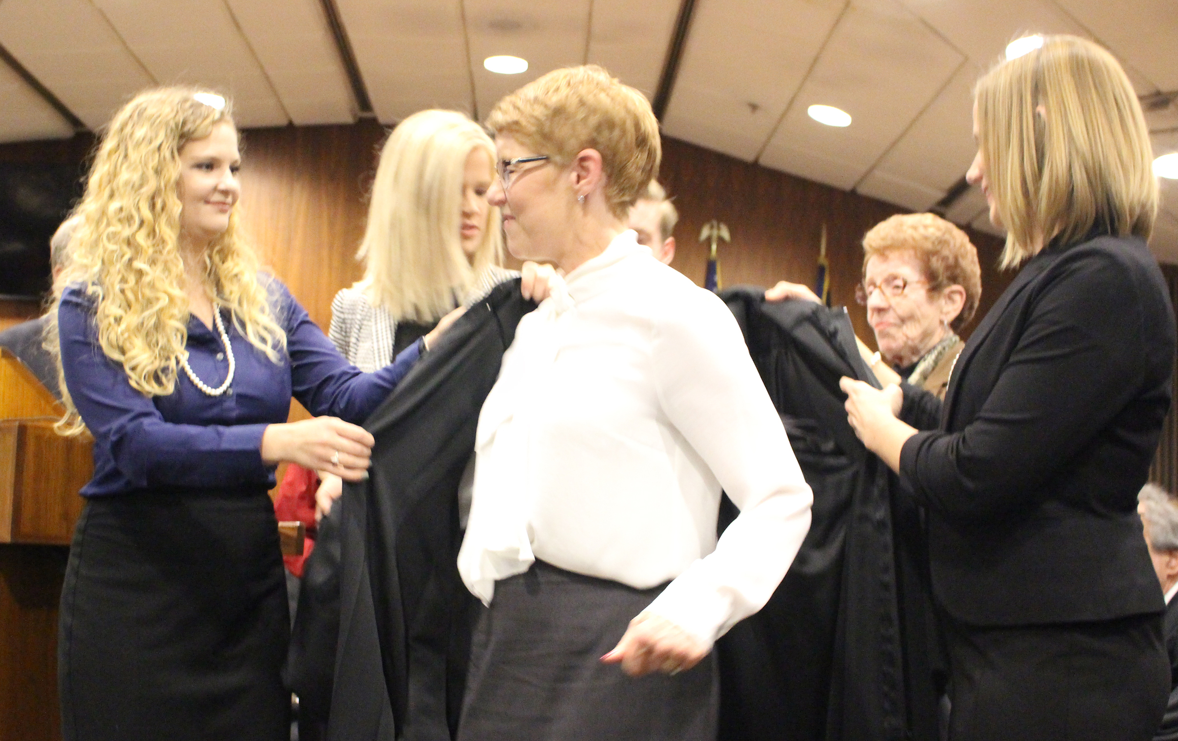Douglas County Juvenile Court Judge Mary “Peg” M.Z. Stevens puts on her robe with assistance from her children during an investiture ceremony in the Legislative Chambers of the Omaha-Douglas County Civic Center on Friday, Jan. 3, 2020. (Photo by Scott Stewart)