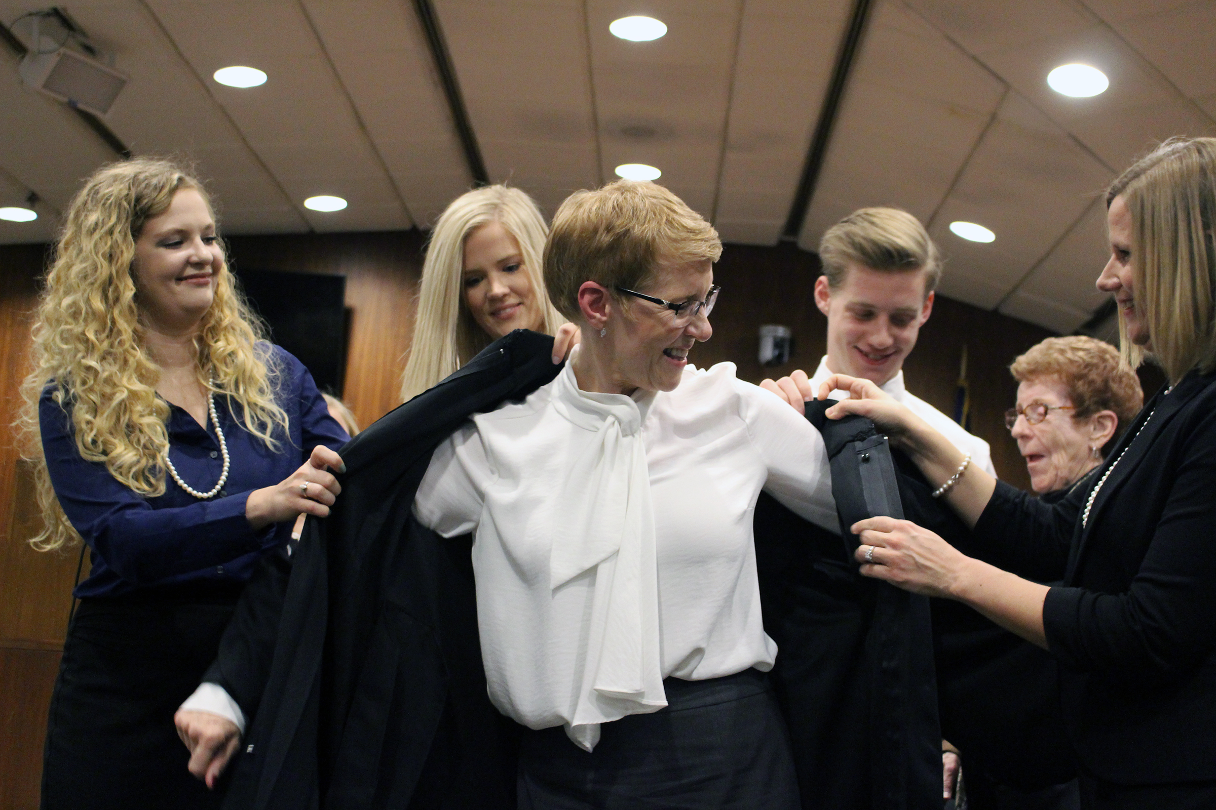 Douglas County Juvenile Court Judge Mary “Peg” M.Z. Stevens puts on her robe with assistance from her children during an investiture ceremony in the Legislative Chambers of the Omaha-Douglas County Civic Center on Friday, Jan. 3, 2020. (Photo by Scott Stewart)