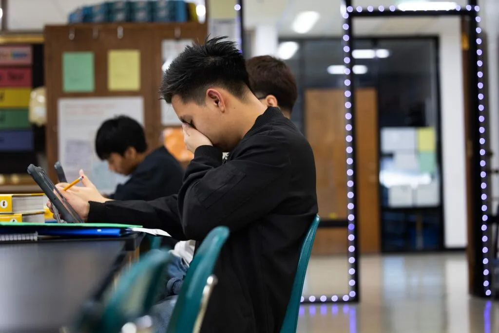 Marco Gutiérrez puts his hand to his face as he works on a study guide in biology class at Schuyler Central High School.<br />(Rebecca S. Gratz / Flatwater Free Press)