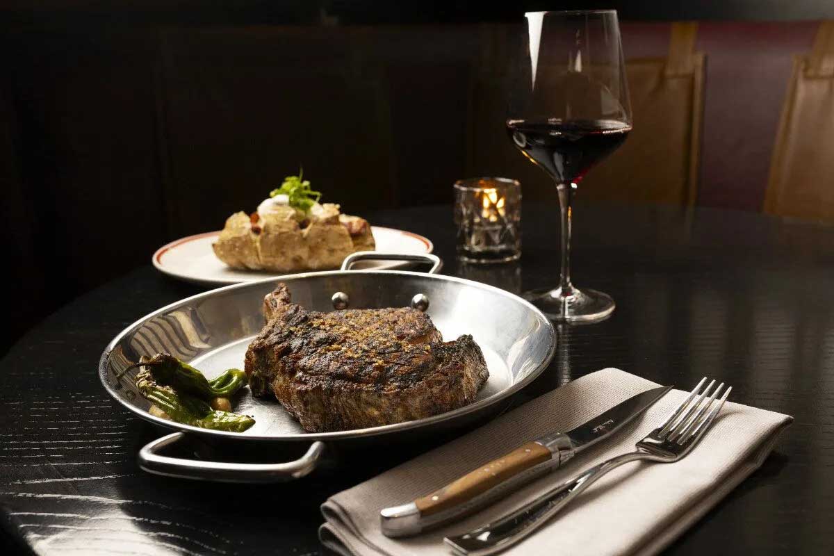 A bone in ribeye and a loaded baked potato are standards of the dinner menu at the Committee Chophouse.<br />(Ryan Soderlin / Flatwater Free Press)