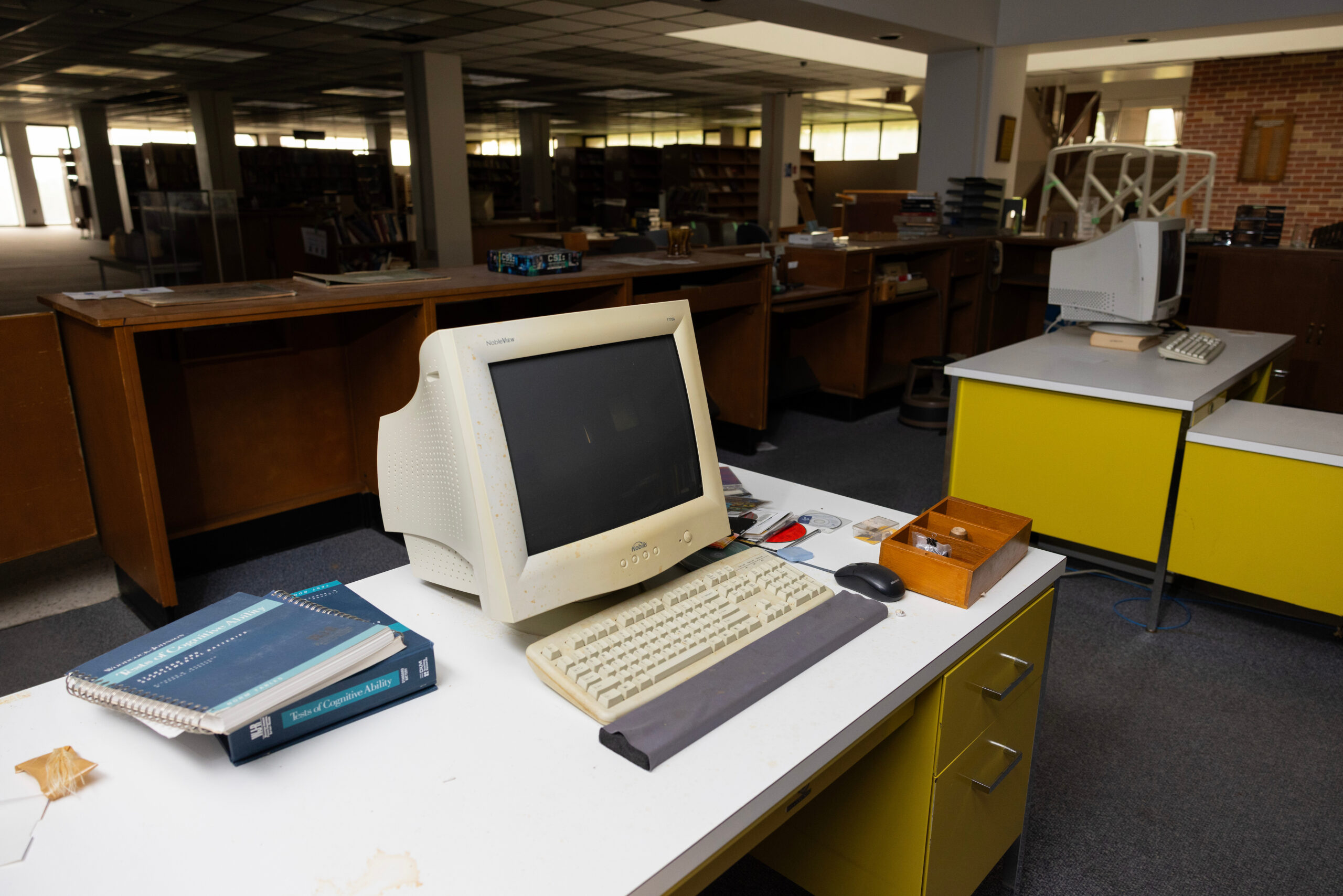 Works stations behind the circulation desk in C.A. Dana-Life Library remain untouched from when the former Dana College closed in 2010 and was photographed on Friday, Sept. 12, 2025, in Blair, Neb.<br />(Rebecca S. Gratz / Nebraska Examiner)