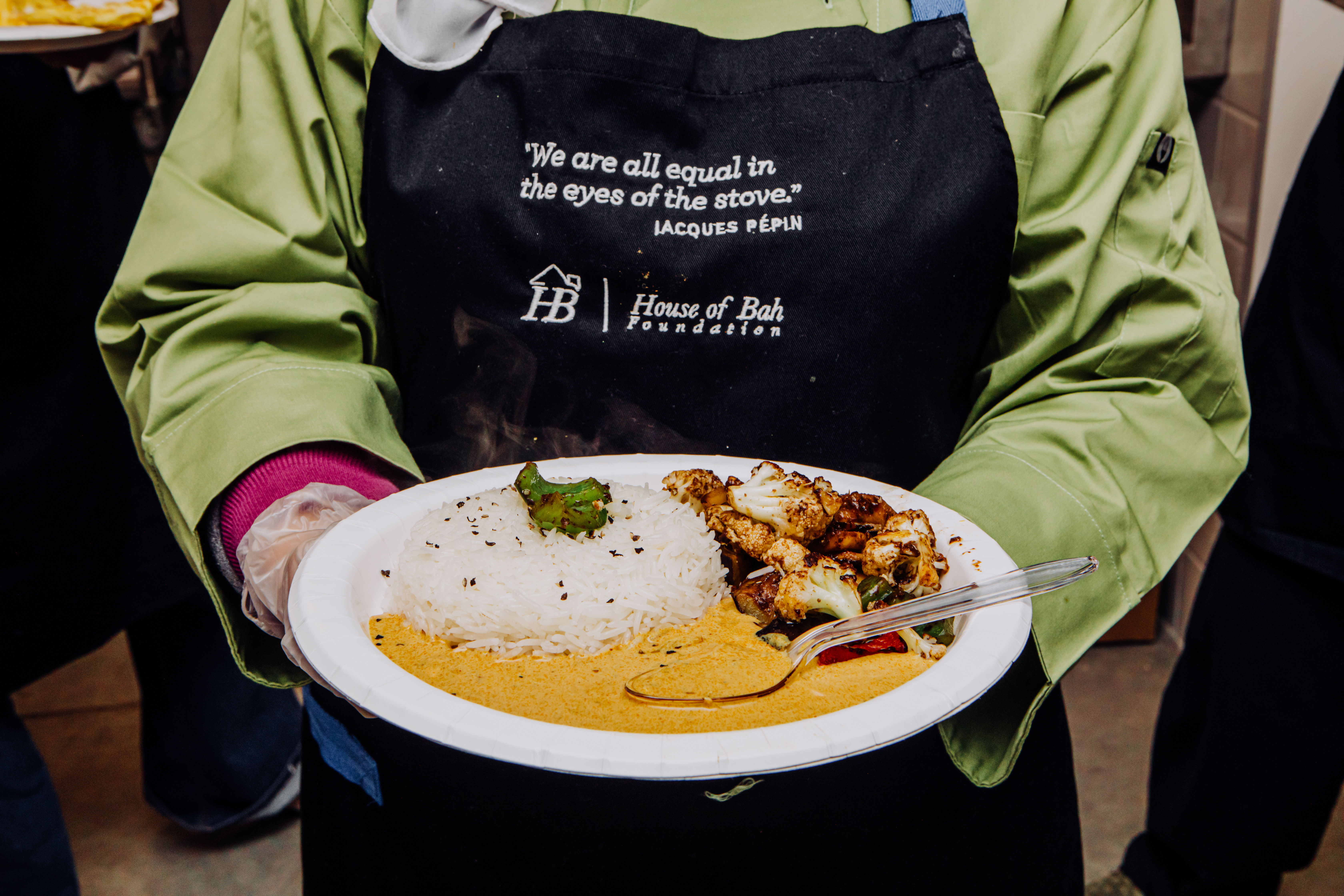 A student in the House of Bah cooking class holds a plate of food prepared by the class.<br />(Joshua Foo / Flatwater Free Press)