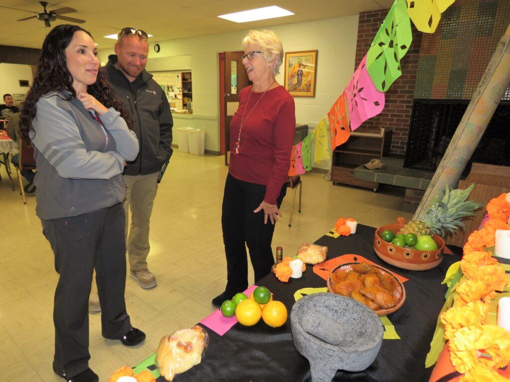 HOPE-Esperanza Executive Director TinaMaria Fernandez (left) her husband Jacob Bear and board member Dr. Janet Evans, all of North Platte, talk at a mixer on Oct. 29, 2024. The nonprofit has helped thousands of people in need in North Platte, and now is helping to ready the city for an influx of new meatpacking plant employees.<br />(Lori Potter / Flatwater Free Press)